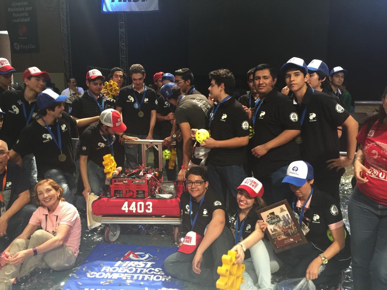 A group wearing medals gathers around a red competition robot numbered 4403.